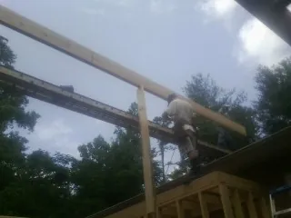 Carpenter setting a ridge beam over a new addition frame — Ice Dam Removal by Roofing Brothers in New Egypt