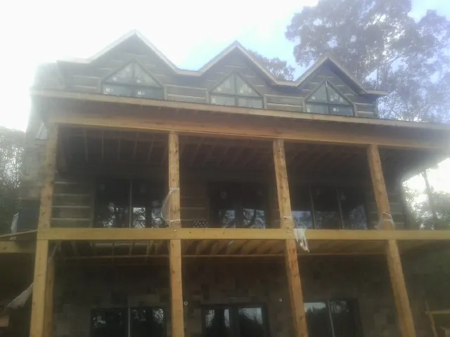 Dormers and porch framing on a large log home under construction — Roof Coating work by our crew in New Egypt