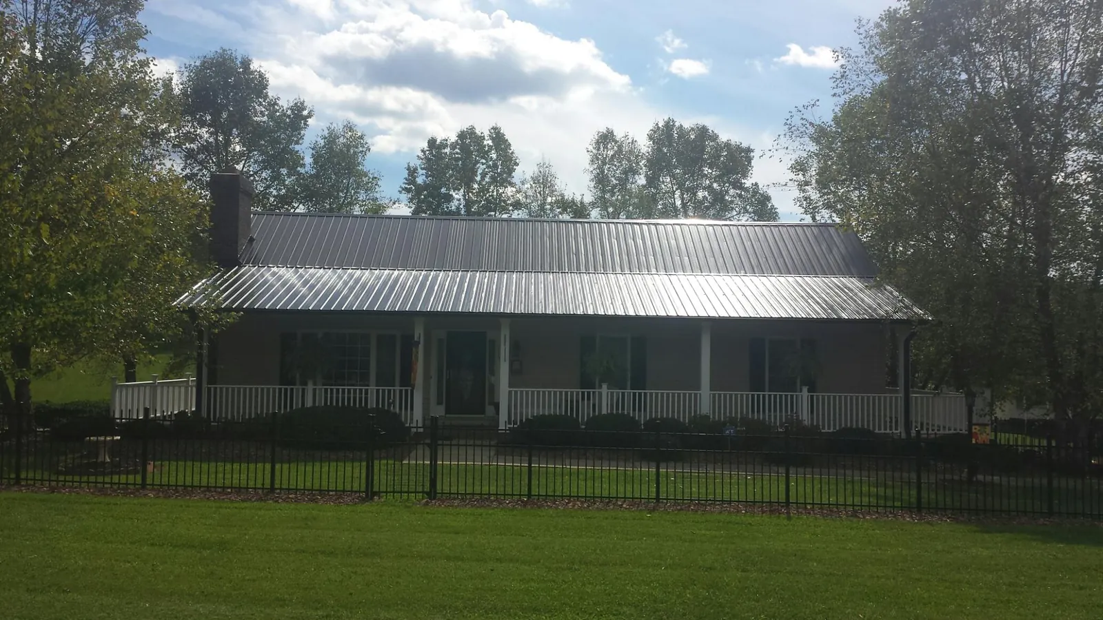 Gray metal roof on a brick ranch with a full width front porch — Gutter Guard Installation work by our crew in New Egypt
