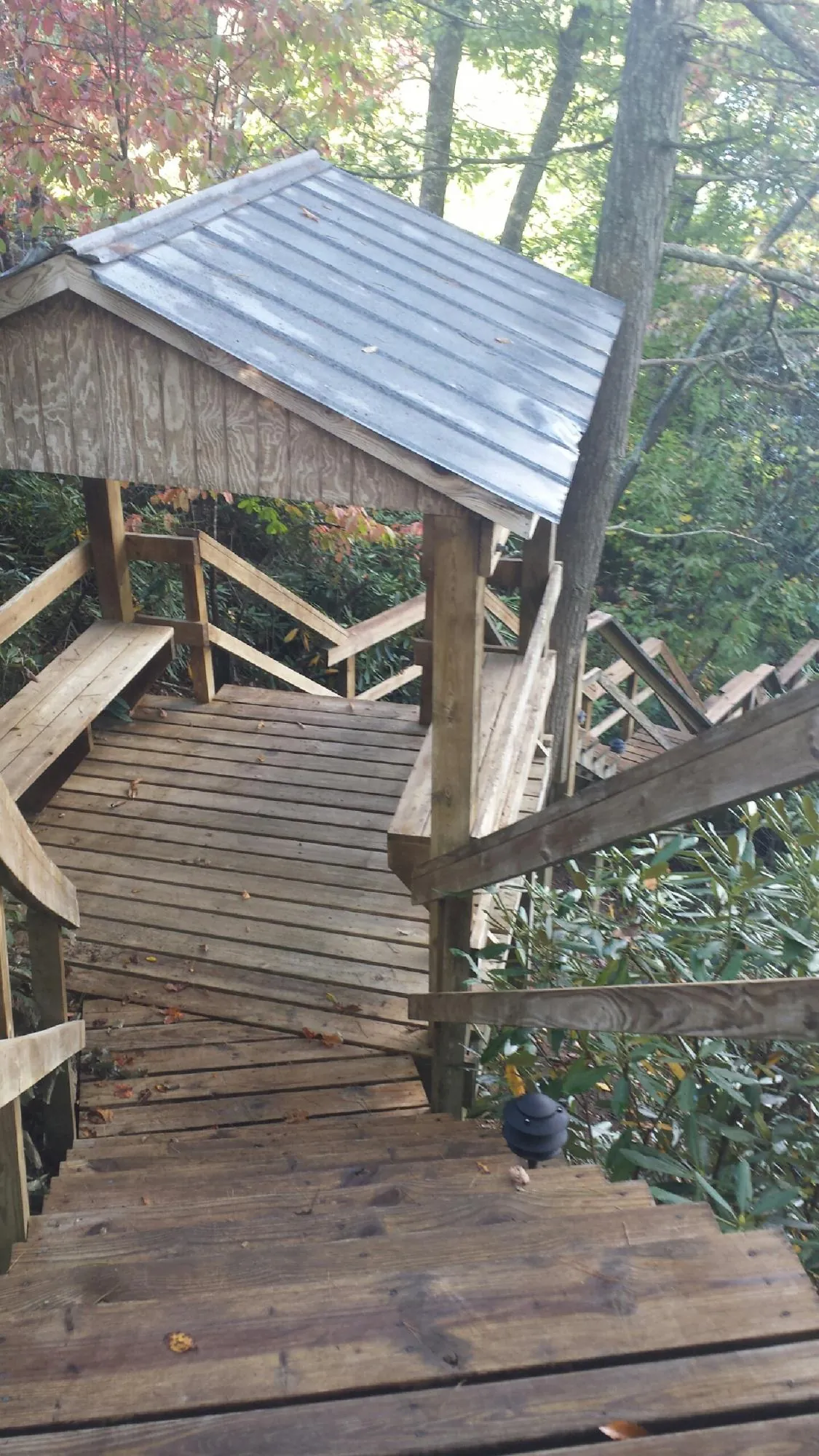 Metal roofed shelter over wooden steps on a wooded walkway — Skylight Repair & Installation work by our crew in New Egypt